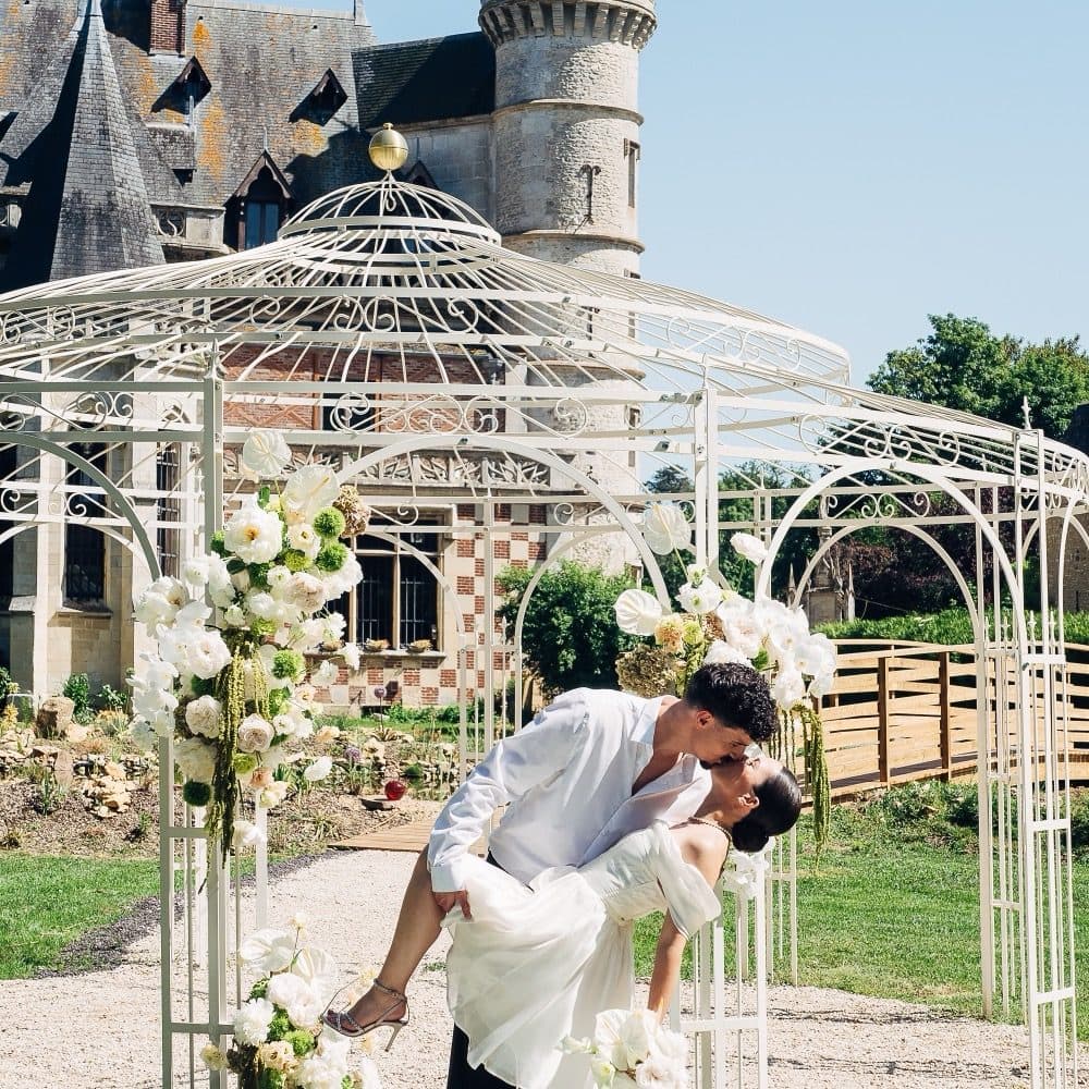 Couple de mariés sous le kiosque fleuri