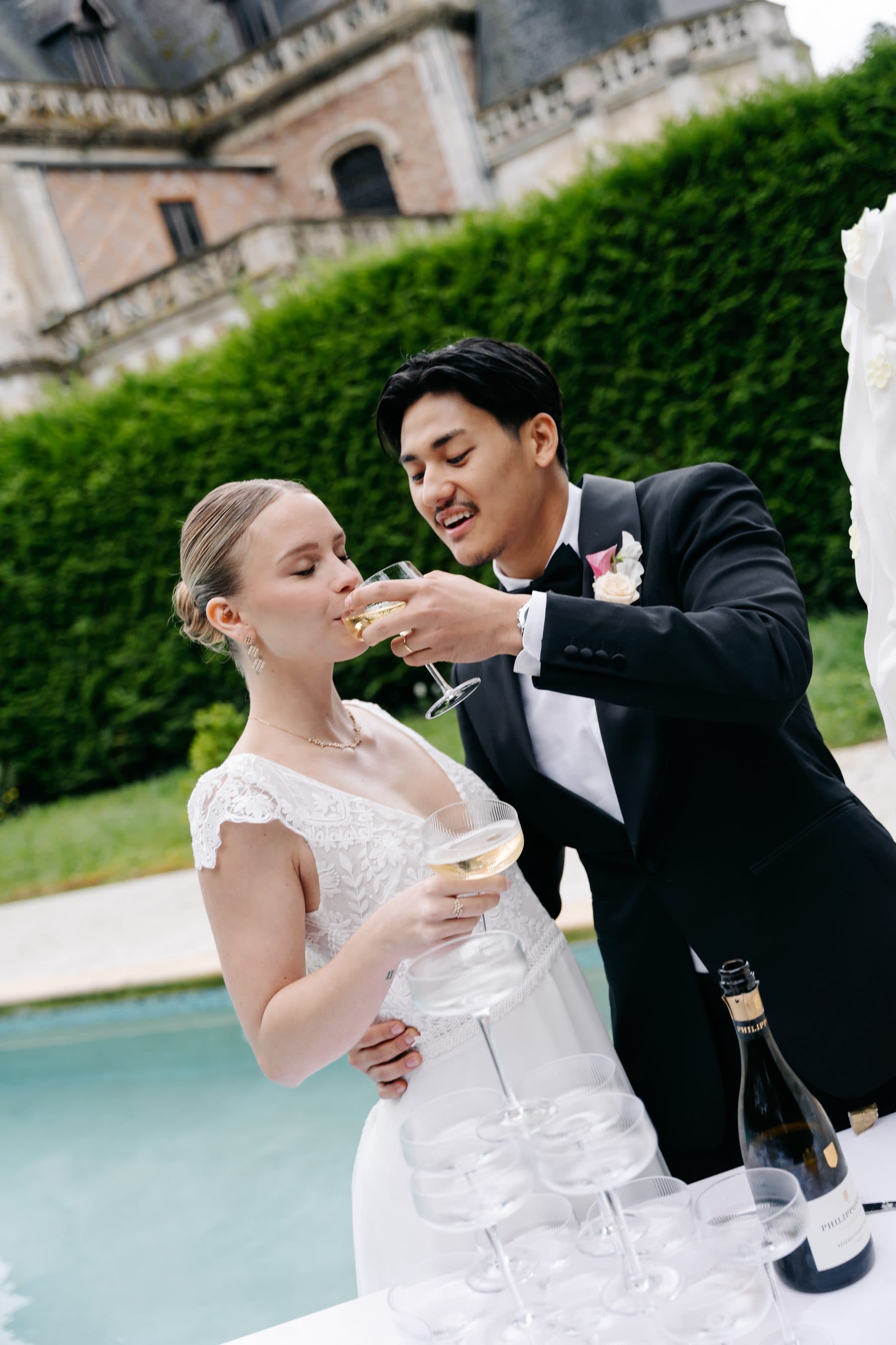 Les mariés trinquant au bord de la piscine du domaine