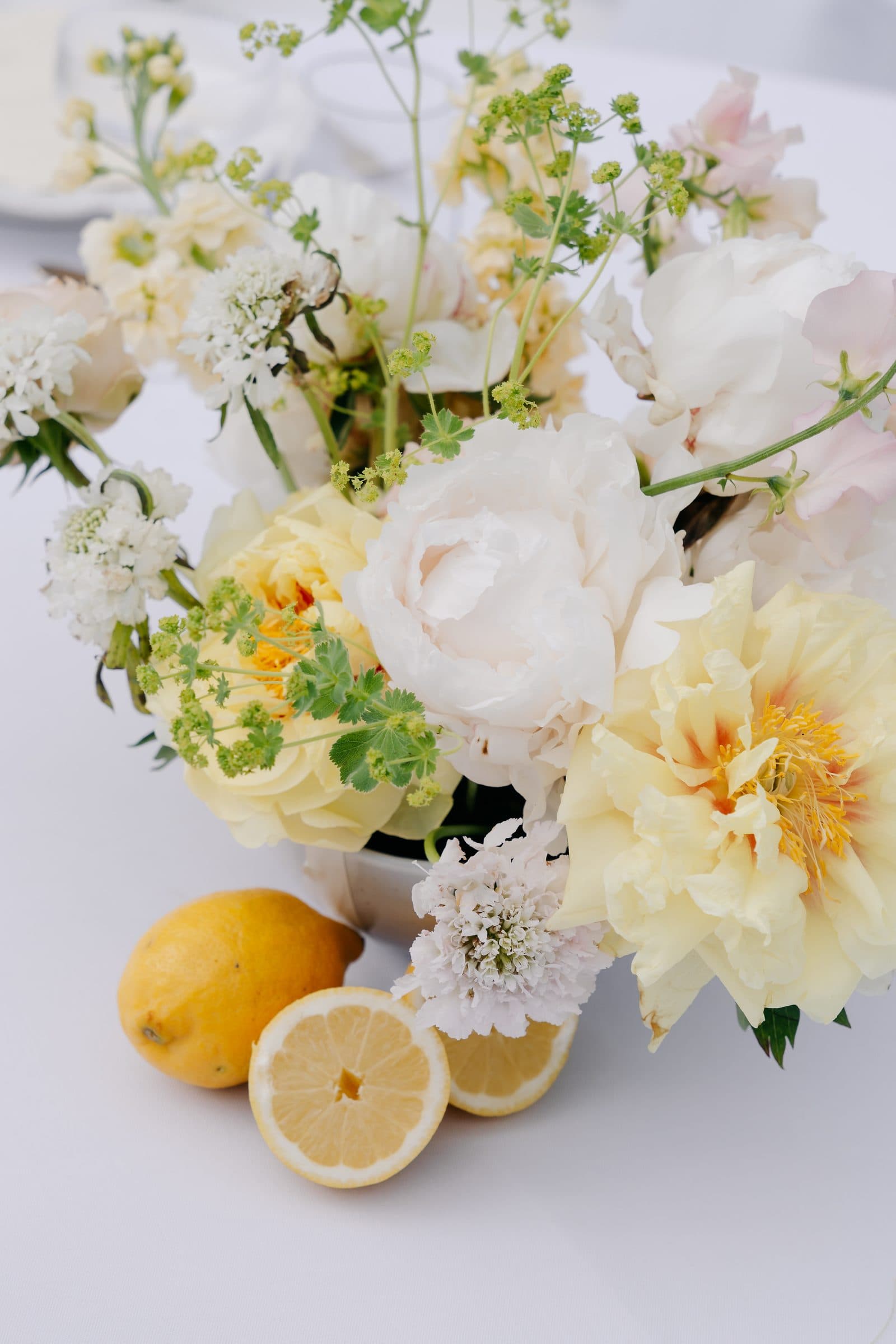 Bouquet de saison et citrons sur nappe blanche