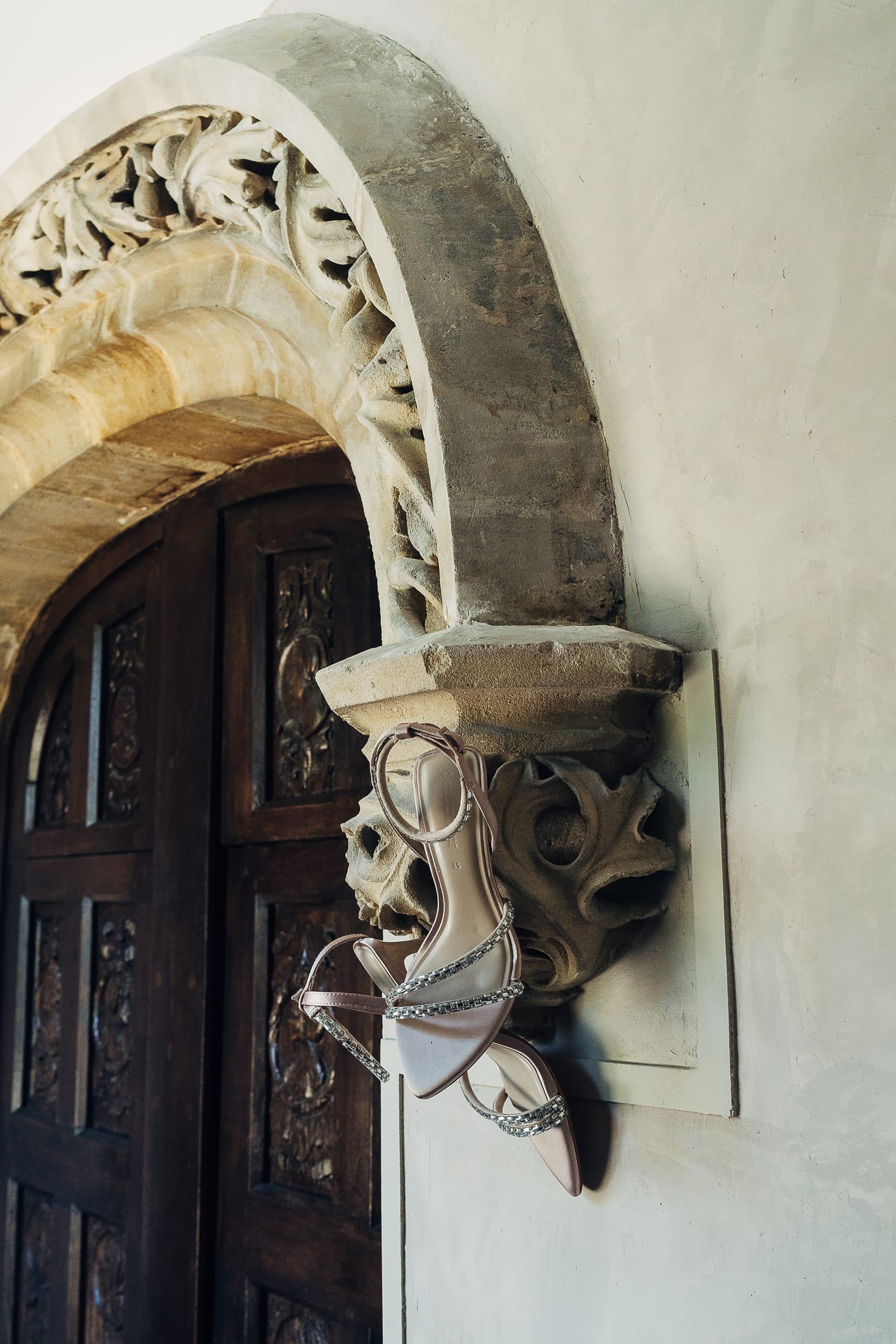 Souliers de la mariée accrochés à un corbeau de pierre sculpté