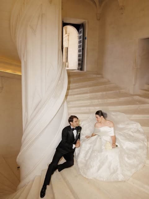 Image de film de mariage signée Maxime, les mariés sur un grand escalier